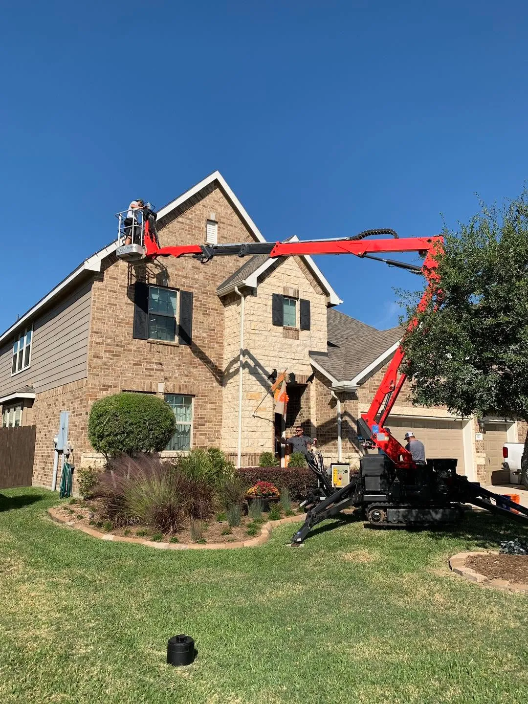 Hanging Christmas lights during the day from a man lift