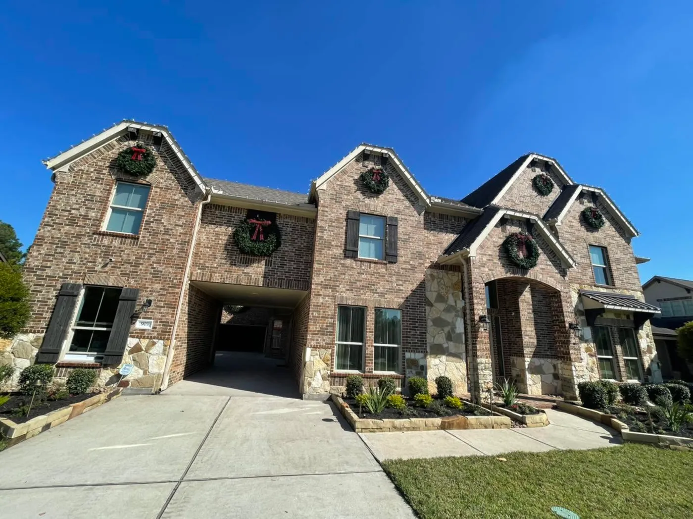 Large house with all the Christmas lights and wreaths hanged during the day